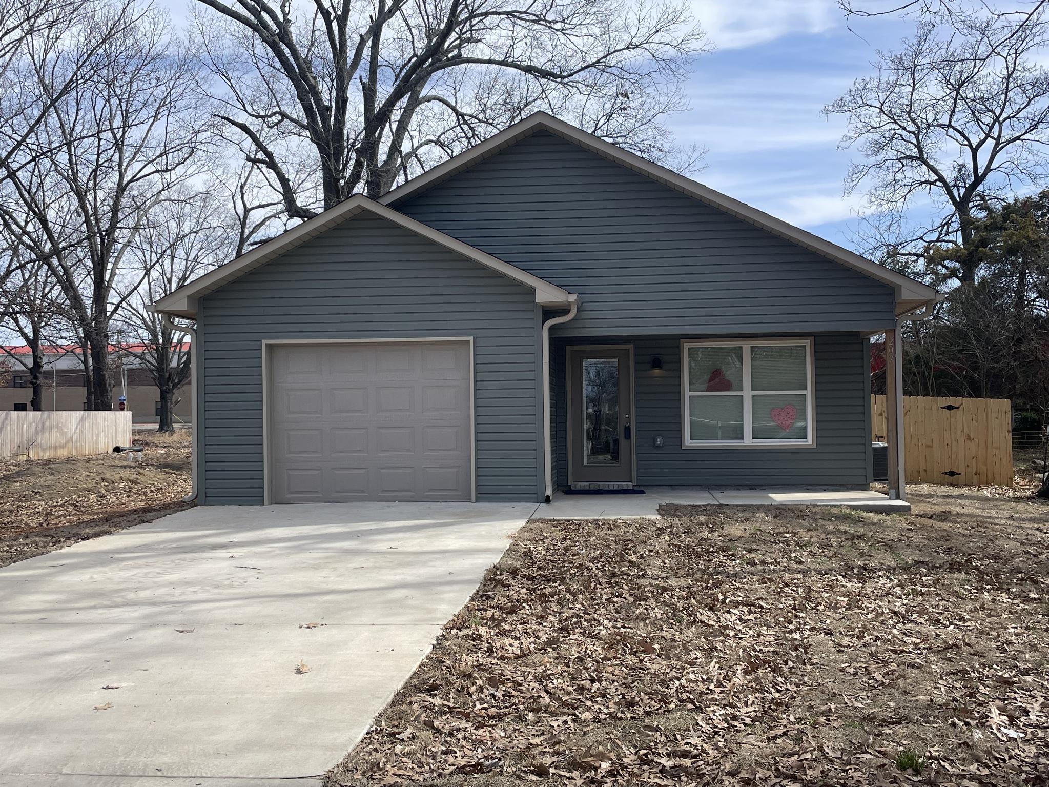 Gray-sided home with garage and concrete driveway