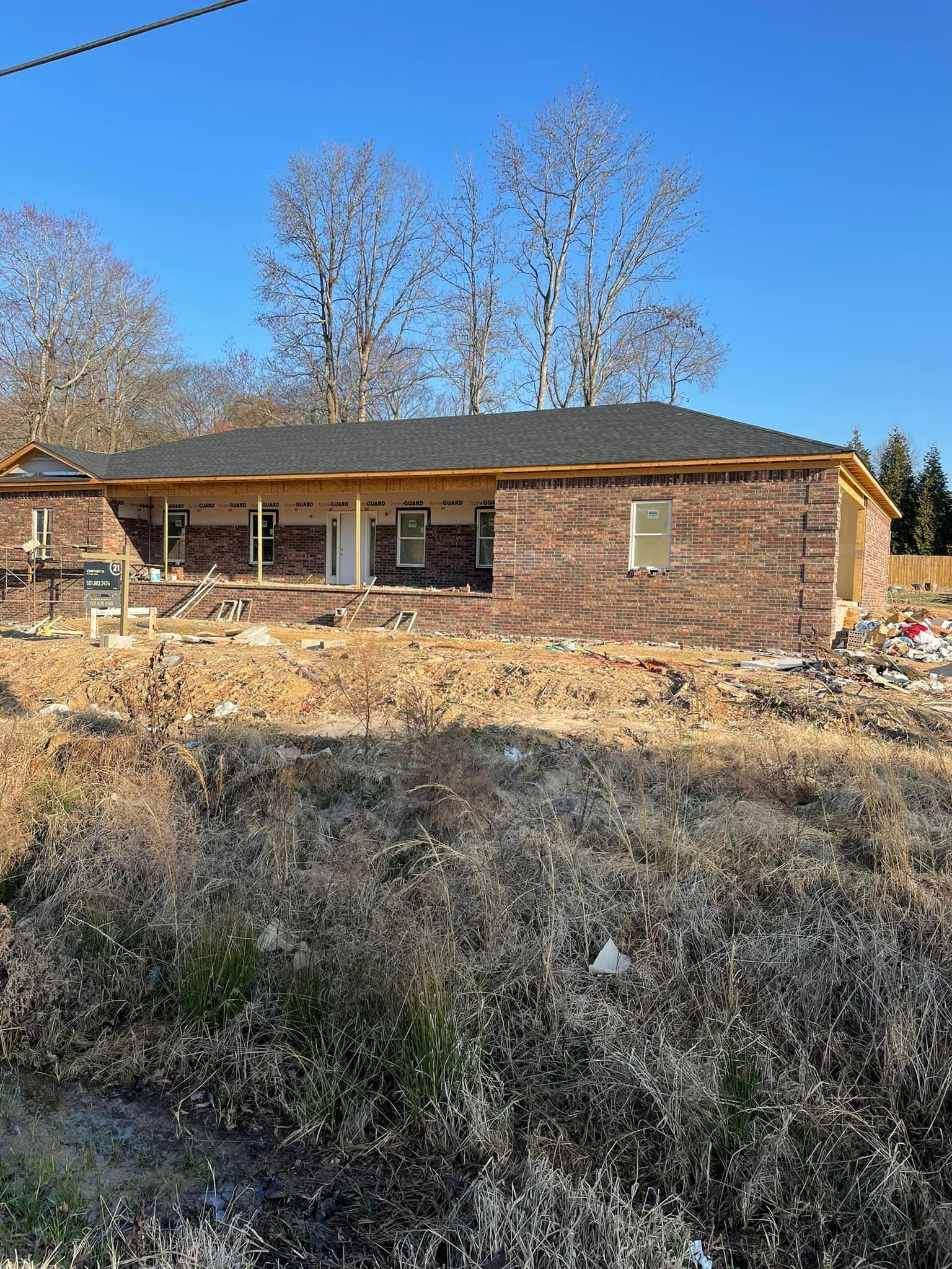 Brick home in progress with roof and windows installed